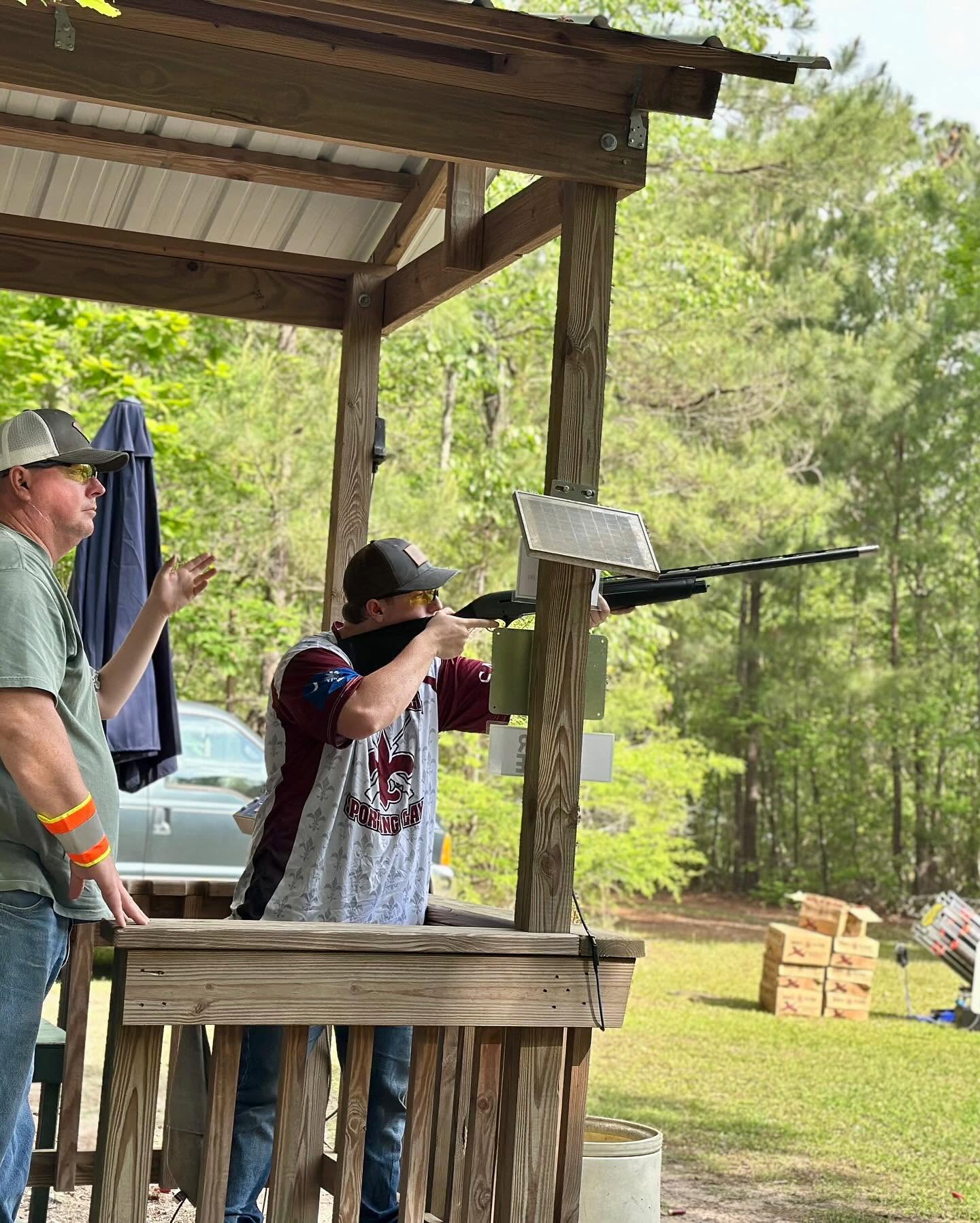 Clarendon Hall Sporting Clays athlete taking a shot alongside an adult at a course station