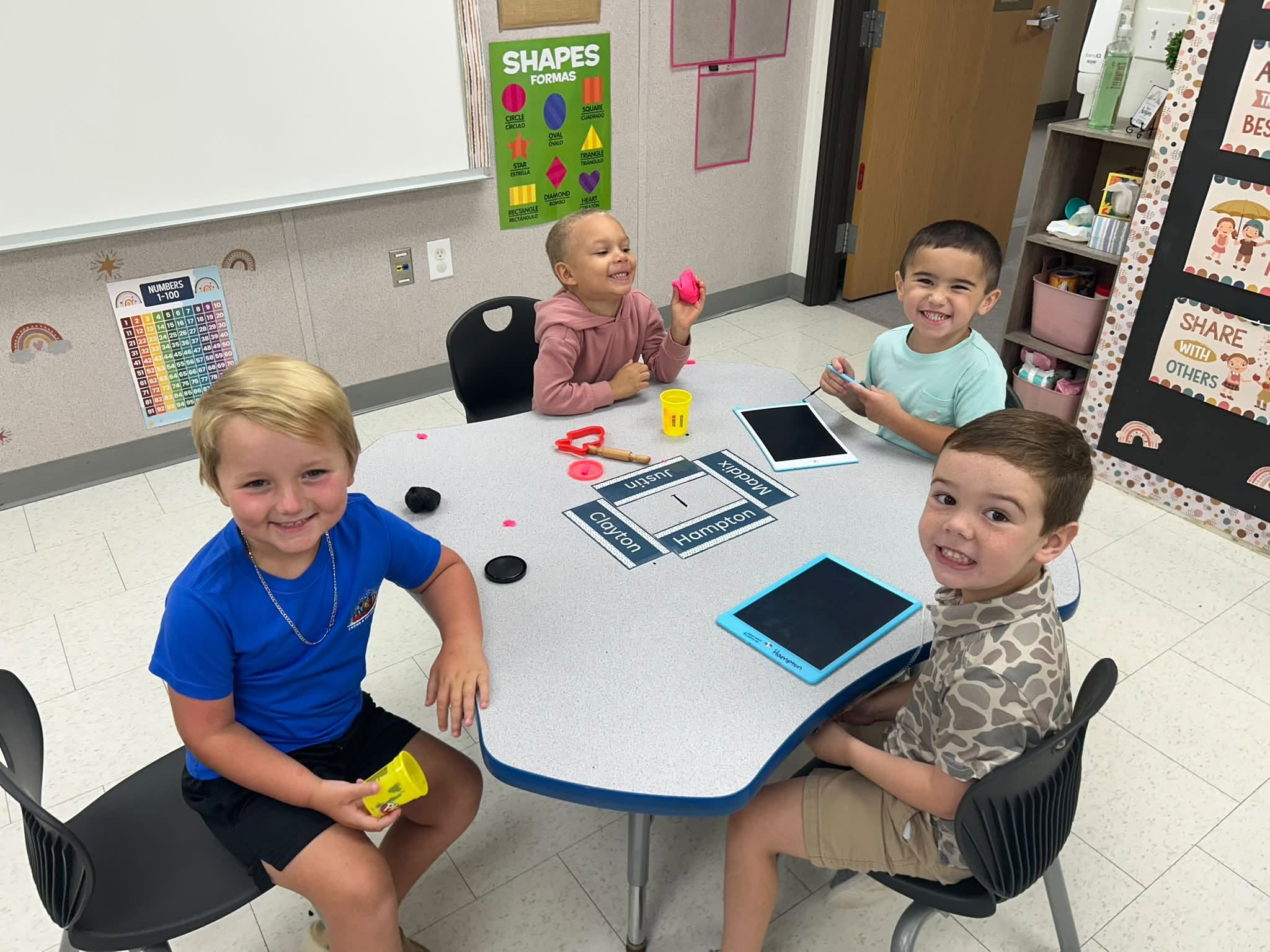 Clarendon Hall preschool students learning with Play-Doh and writing tablets