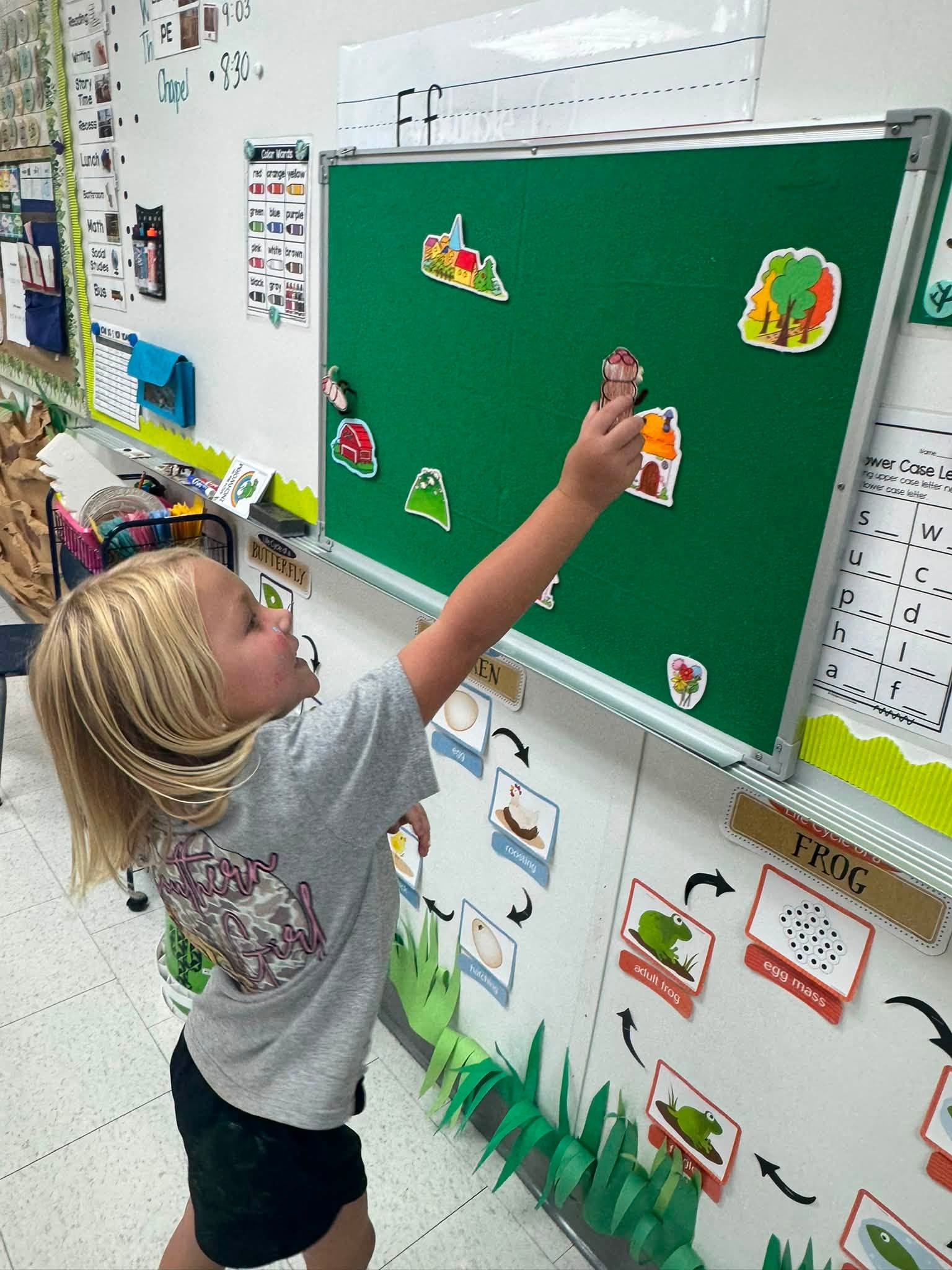 A Lower School student exploring a classroom learning board